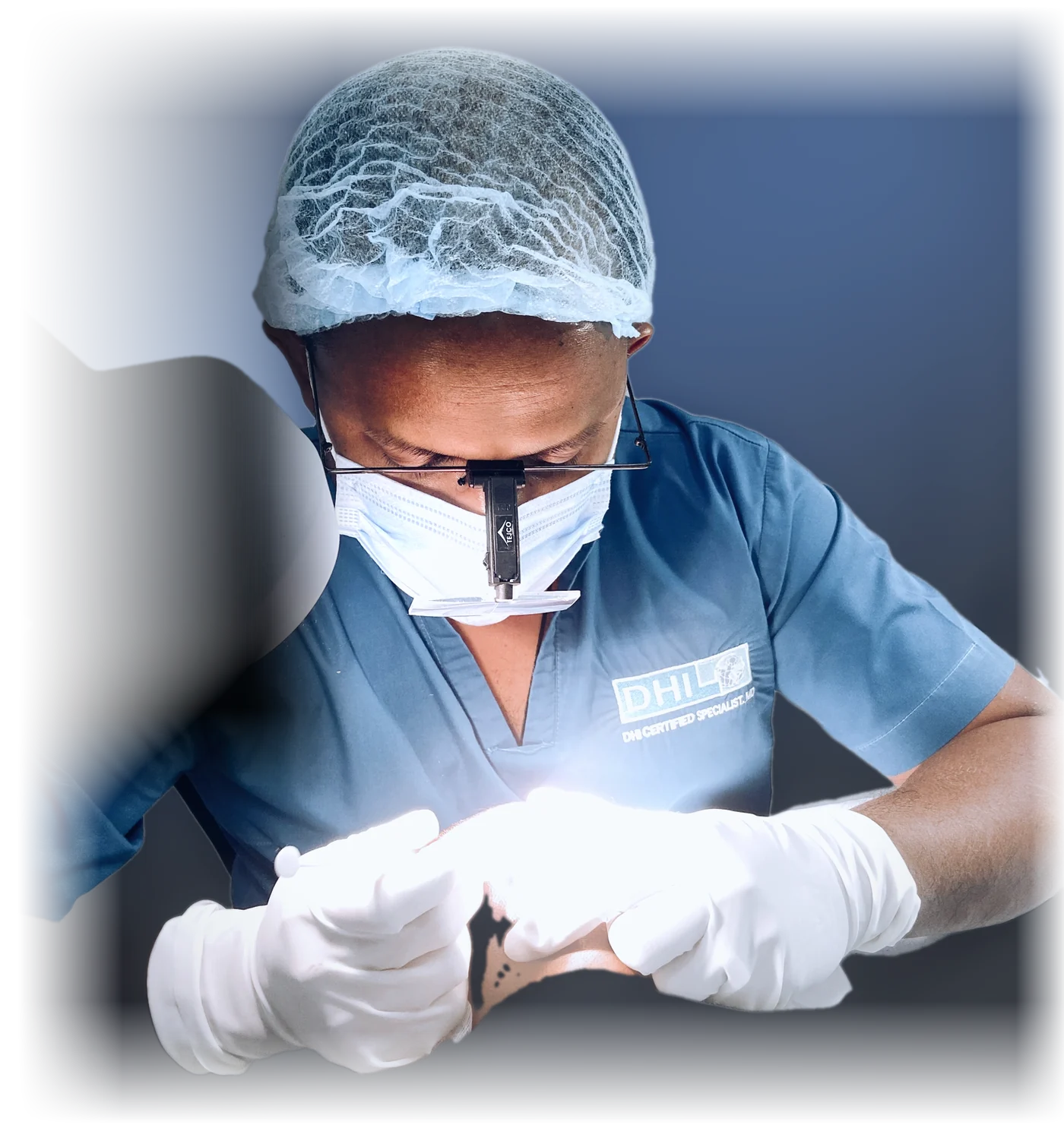 Upul Narandeniya, in surgical scrubs and loupes, placing grafts during a hair transplant procedure.